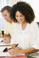 Mid adult woman studying with other adult students