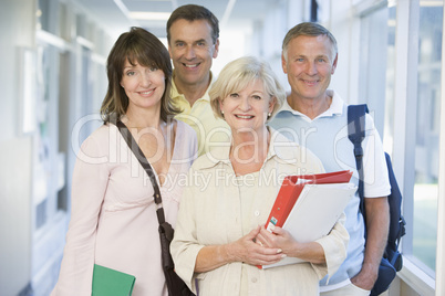 A group of adult students with backpacks standing in a campus co