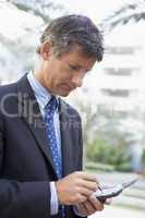 Businessman outdoors using personal digital assistant