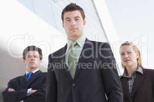 Three businesspeople standing outdoors by building