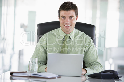 Businessman sitting in office with personal organizer using lapt