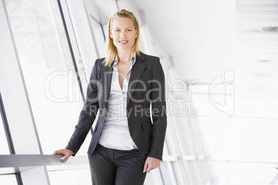 Businesswoman standing in corridor smiling