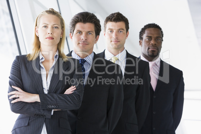 Four businesspeople standing in corridor