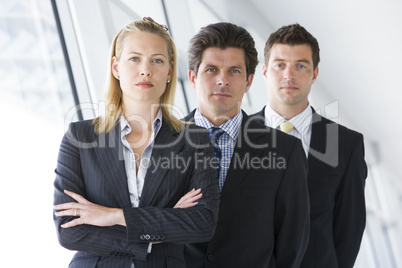 Three businesspeople standing in corridor