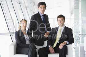 Three businesspeople sitting in office lobby