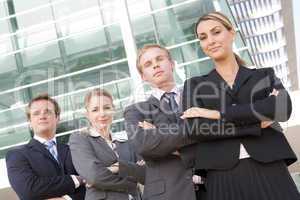 Four businesspeople standing outdoors smiling