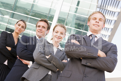 Four businesspeople standing outdoors smiling