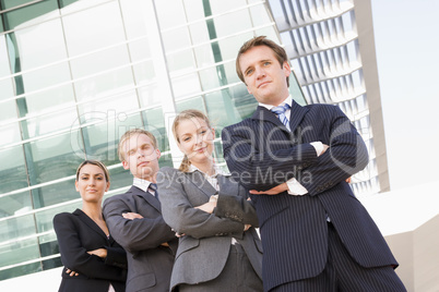 Four businesspeople standing outdoors smiling