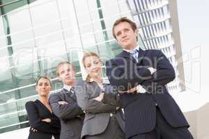 Four businesspeople standing outdoors smiling