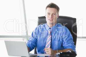 Businessman sitting in office with laptop