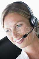 Businesswoman in office wearing headset and smiling