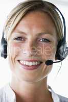 Businesswoman in office wearing headset and smiling