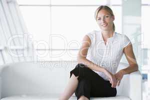 Businesswoman sitting in office lobby smiling
