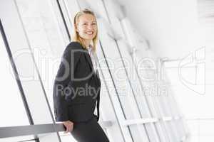 Businesswoman standing in corridor smiling