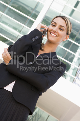 Businesswoman standing outdoors on cellular phone smiling