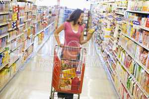 Woman shopping in supermarket aisle