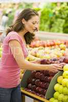 Woman choosing apples in produce department