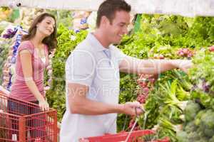 Young couple flirting in supermarket aisle