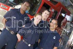 Portrait of firefighters standing by a fire engine