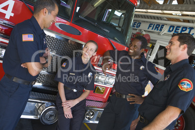 Firefighters chatting by a fire engine