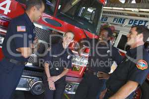 Firefighters chatting by a fire engine