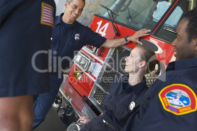 Firefighters chatting by a fire engine