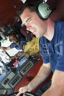 A firefighter driving a fire engine