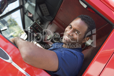 A firefighter sitting in the cab of a fire engine