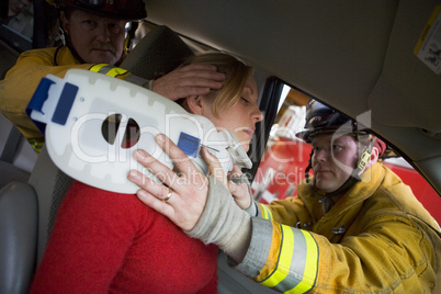 Firefighters helping an injured woman in a car