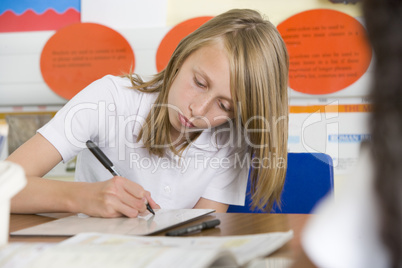 A schoolgirl studying in class