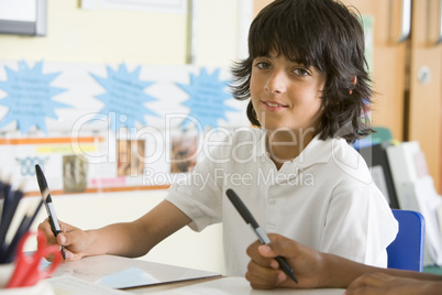 A schoolboy studying in class