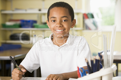 A schoolboy studying in class