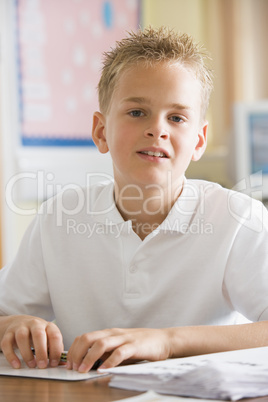 A schoolboy studying in class