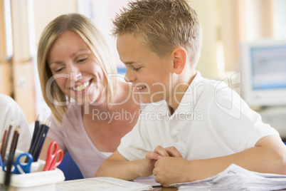 A schoolboy sitting with his teacher in class