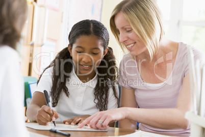 A schoolgirl sitting with her teacher in class