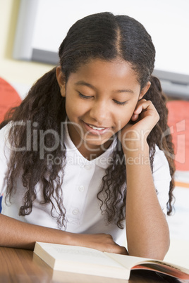 Schoolgirl reading a book in class