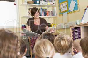 A teacher reads to schoolchildren in a primary class