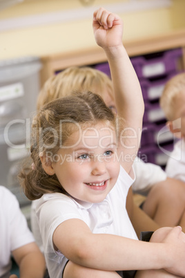 A schoolgirl raises her hand in a primary class