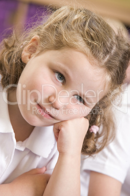 Bored schoolgirl sitting in primary class