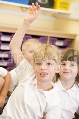 A schoolgirl raises her hand in a primary class