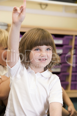 A schoolgirl raises her hand in a primary class