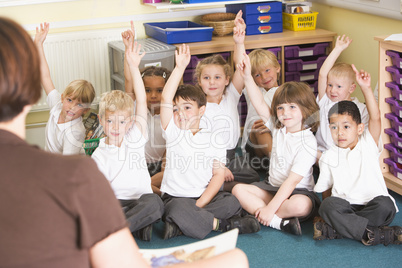 Schoolchildren raise their hand in a primary class