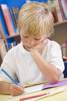 A schoolboy sitting in a primary class