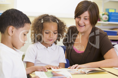 Schoolchildren and their teacher reading in a primary class