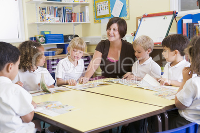 Schoolchildren and their teacher reading in primary class