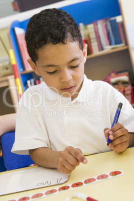 Boy learning to write numbers in primary class