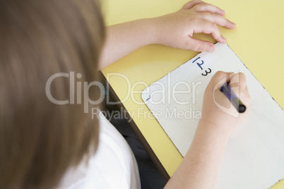 Girl learning to write numbers in primary class