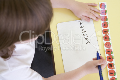Girl learning to write numbers in primary class