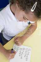 Girl learning to write name in primary class