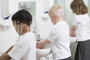 Children washing their hands in a primary school bathroom